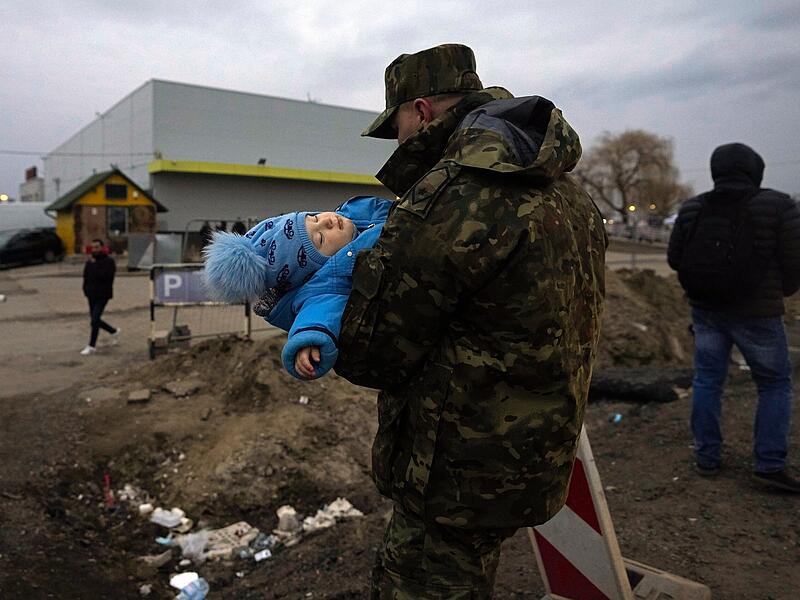 Ein polnischer Soldat tr&auml;gt das Baby eines ukrainischen Fl&uuml;chtlings bei der Ankunft am polnischen Grenz&uuml;bergang in Medyka.