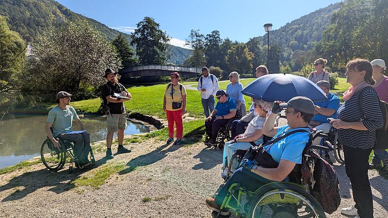 Ranger Johannes Stemper (mit Hut), daneben im Rollstuhl: Dominik Herrmann, berichtet mit Bildern und in leichter Sprache beim Aktionstag in Muggendorf im vergangenen Jahr &uuml;ber Tiere und Pflanzen in der Wiesent.