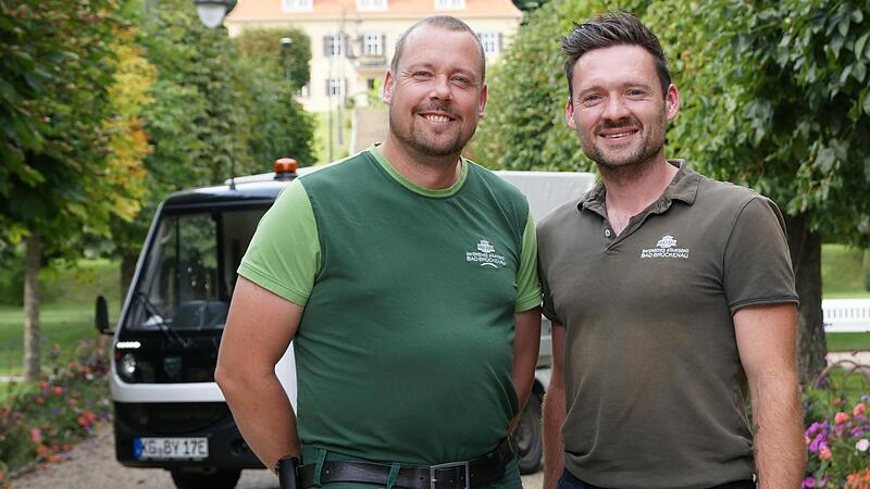 Holger Börner (links) und Michael Jacob unternehmen als Leiter der Kurgärtnerei viel, damit der Park im Staatsbad trotz extremer werdenden Wetters grün und vielfältig bleibt. Unter anderem laufen die meisten ihrer Fahrzeuge seit Jahren elektrisch.