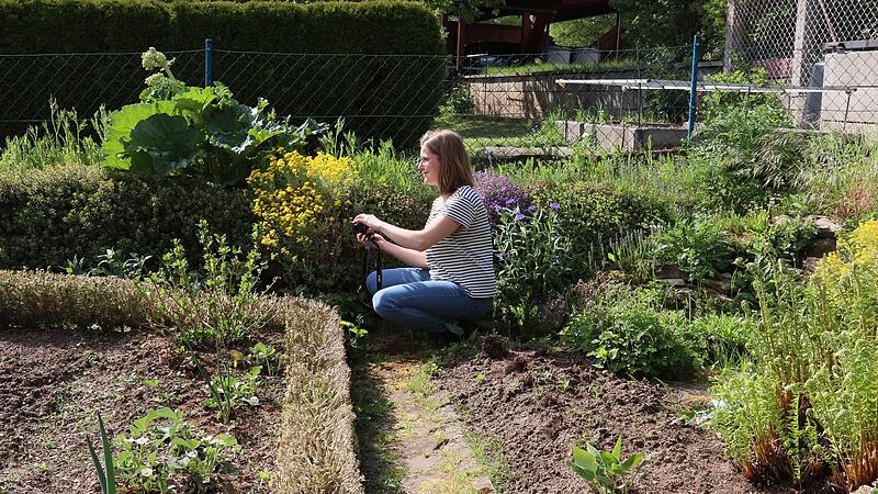 LBV und LfU zeichnen vogelfreundliche Gärten aus. Bewerterin Charlotte Asen dokumentiert mit der Kamera die Mischung aus Gemüsebeten, Steinmauern und wilden Ecken im Garten der Familie Rothemund.LBV/LfU Auszeichnung vogelfreundlicher Gärten