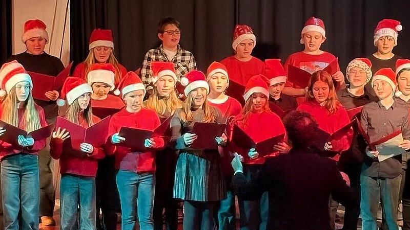 Auch der rot gekleidete Unterstufenchor mit Nikolausmützen unter der Leitung von Christian Moll trat auf. Auch der rot gekleidete Unterstufenchor mit Nikolausmützen unter der Leitung von Christian Moll trat auf.
