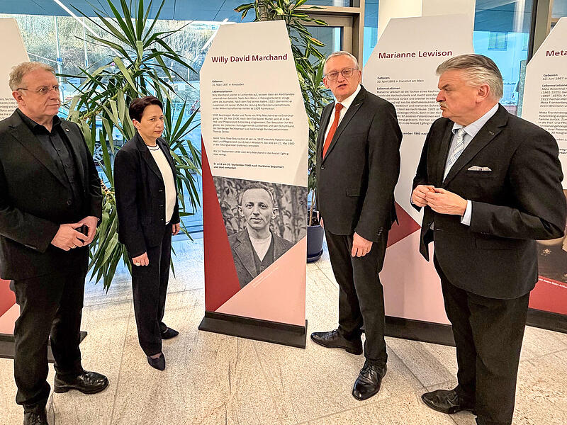 Bezirksheimatpfleger G&uuml;nter Dippold beim Durchgang durch die Ausstellung &bdquo;Doppelt stigmatisiert&ldquo;, die im Foyer des im Klinikums Kulmbach er&ouml;ffnet worden ist.  Rechts von ihm Landrat Klaus Peter S&ouml;llner, links Bezirkstagspr&auml;sident Henry Schramm und Gesch&auml;ftsf&uuml;hrerin Brigitte Angermann.