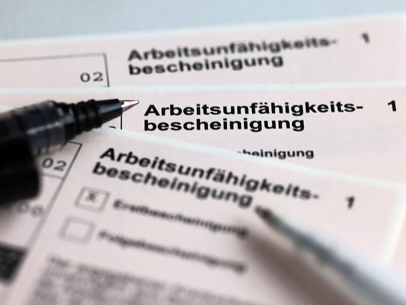 Stifte liegen auf Arbeitsunf&auml;higkeitsbescheinigungen