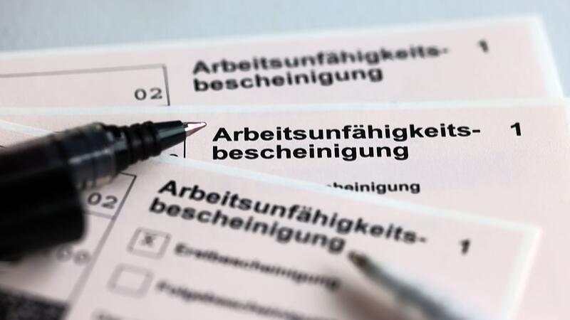 Stifte liegen auf Arbeitsunf&auml;higkeitsbescheinigungen