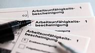 Stifte liegen auf Arbeitsunf&auml;higkeitsbescheinigungen