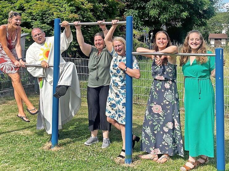 Diakon Manfred M&uuml;ller und zweite B&uuml;rgermeisterin Elisabeth Assmann zusammen mit dem Orga-Team bei der Spielplatzsegnung im Juni 2025 mit dem neu angeschafften Reck