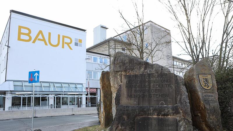 Vor dem Lager in Altenkunstadt steht ein Gedenkstein mit einem Leitspruch des Firmengr&uuml;nders Friedrich Baur. An diesem Standort wird bald ein neues Lager f&uuml;r &uuml;ber 150 Millionen Euro entstehen.
