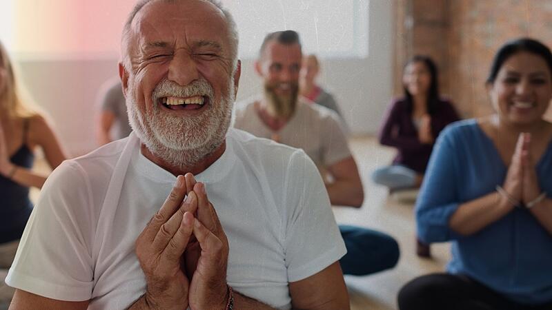 Smiling old man in yoga class Lach-Yoga ist nur einer von vielen originellen oder besonderen Kursen im Programm der Volkshochschulen. In Erlangen und Erlangen-Höchstadt beginnt diesen Monat das Herbst-/Wintersemester mit abwechslungsreichen Kursen. (Symboldbild)