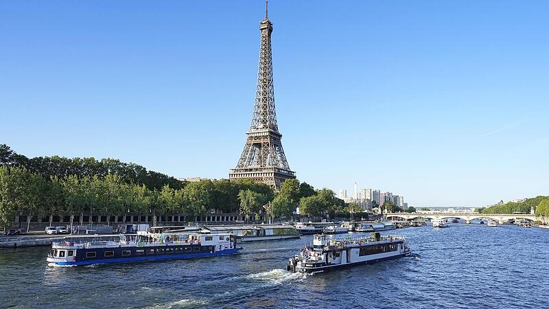 Ein Boot und ein Lastkahn fahren vor dem Eiffelturm auf der Seine w&auml;hrend eines Tests f&uuml;r die Er&ouml;ffnungsfeier der Olympischen Spiele 2024 in Paris.