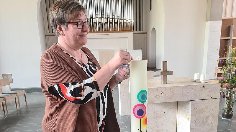 Elke Dollinger z&uuml;ndet in der Kirche eine Kerze an.