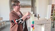 Elke Dollinger z&uuml;ndet in der Kirche eine Kerze an.