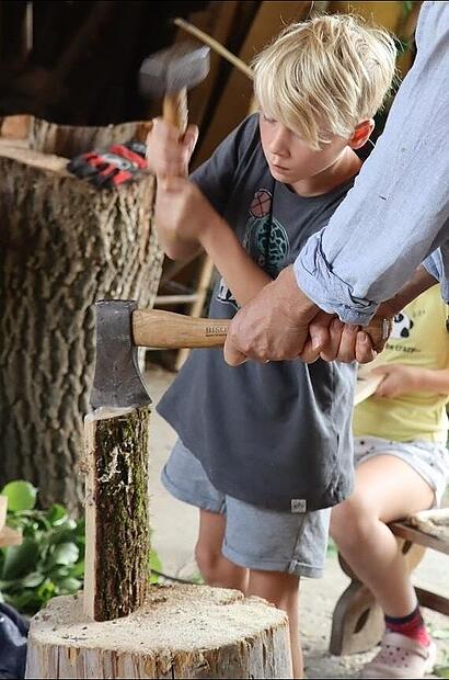 Zusammen mit Eckart Henzler hackt Josef die rohen Holzteile, die f&uuml;r L&ouml;ffel und Pfannenschieber ben&ouml;tigt werden, in Form.