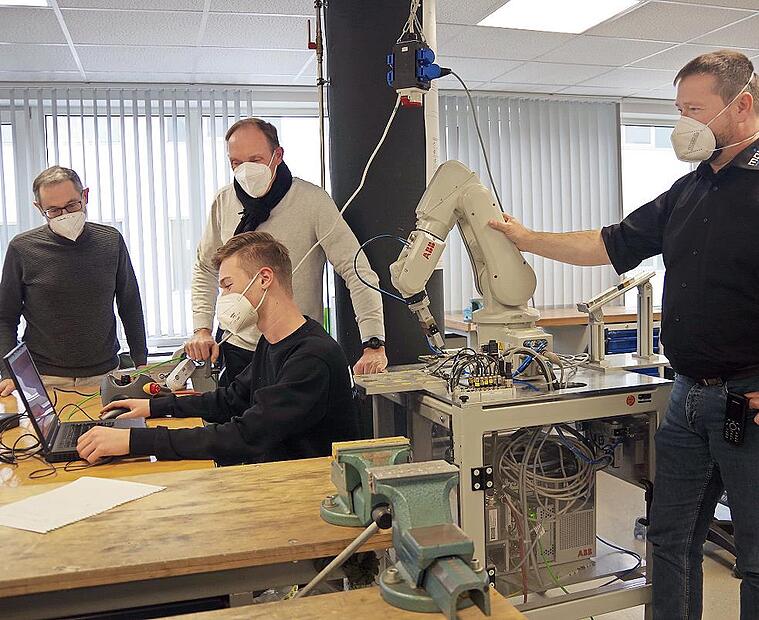 Im Auszubildenden-Zentrum der Firma M.A.i. in Neuses schauen (von links) David Márquez, Werner Zahner und Tobias Geiger dem Azubi Marius (vorne) über die Schulter.