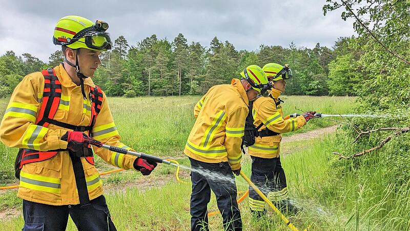 Demonstration der Waldbrandbekämpfung: Lukas Ort (von links) löscht mit der Handpumpe die letzte Glut, die Sven Neder mit der Hacke im Waldboden freigelegt hat, während Michael Schmitt mit dem speziellen D-Schlauch einen größeren Brandherd löscht. Demonstration der Waldbrandbekämpfung: Lukas Ort (von links) löscht mit der Handpumpe die letzte Glut, die Sven Neder mit der Hacke im Waldboden freigelegt hat, während Michael Schmitt mit dem speziellen D-Schlauch einen größeren Brandherd löscht.