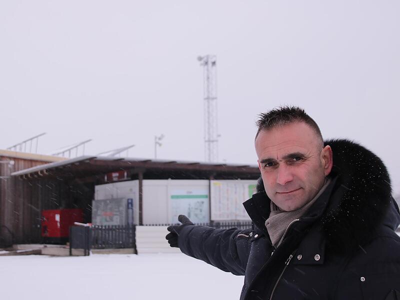 Thomas Schmitt am Generatorenhaus mit Solaranlage, dahinter der Sendemast auf dem Messegel&auml;nde
