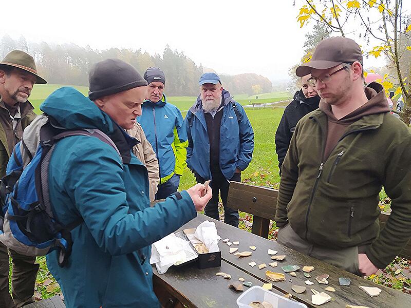 Ralf Obst, Archäologe beim Landesamt für Denkmalpflege auf Schloss Seehof (Zweiter von links), begutachtet zusammen mit den Teilnehmern der Exkursion das von Ehrenamtlern aufgefundene Keramikmaterial aus dem Bereich der Ruine Raueneck.