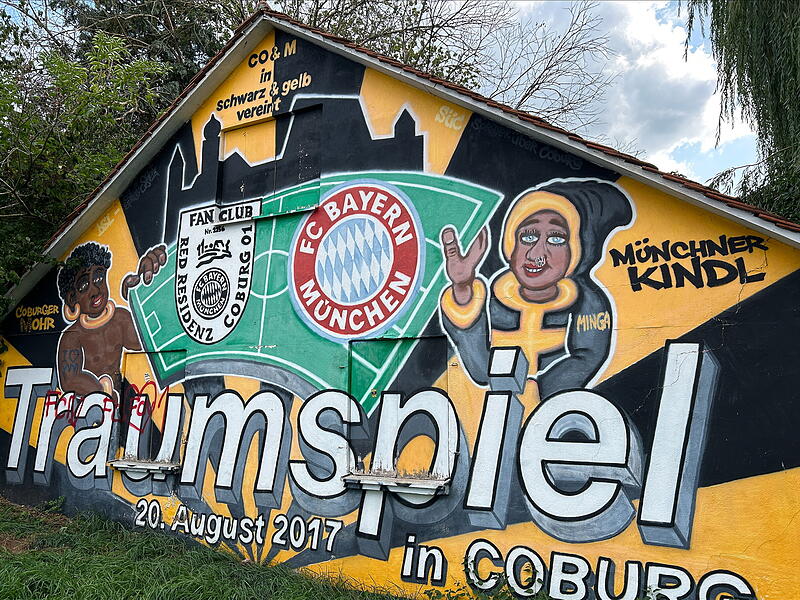 Am 20. August 2017 gastierte der FC Bayern zum sogenannten Traumspiel in Coburg. Daran erinnert noch ein Wandgem&auml;lde nahe der Stocke-Anlage. Coburger Mohr und M&uuml;nchner Kindl sind darauf ebenso zu sehen wie die Veste.