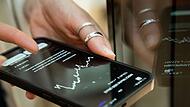 Eine Frau nutzt eine Finanz-App auf einem Smartphone