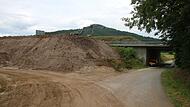 Seit einigen Tagen sind die Bauarbeiten zur Vollendung der Lärmschutzwälle wieder angelaufen. Im Hintergrund ist der Staffelberg zu sehen.
