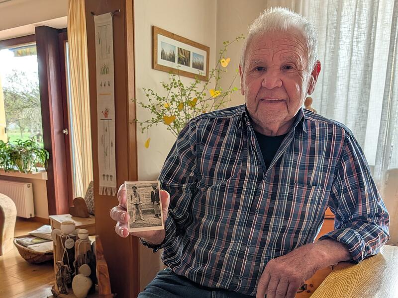 Matth&auml;us Endres in seinem Wohnzimmer mit dem Foto zweier Arbeiter an der Baustelle der Serlbacher Kirche.