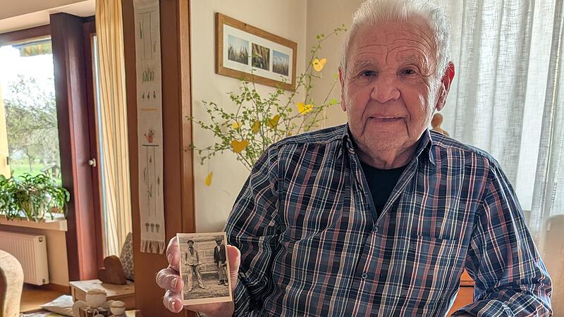 Matth&auml;us Endres in seinem Wohnzimmer mit dem Foto zweier Arbeiter an der Baustelle der Serlbacher Kirche.