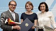 MdB Emmi Zeulner (Mitte) erh&auml;lt von Bundesverkehrsminister Alexander Dobrindt im Beisein von parlamentarischer Staatssekret&auml;rin Dorothee B&auml;r die gute Nachricht f&uuml;r die Region. Foto: Verkehrsministerium