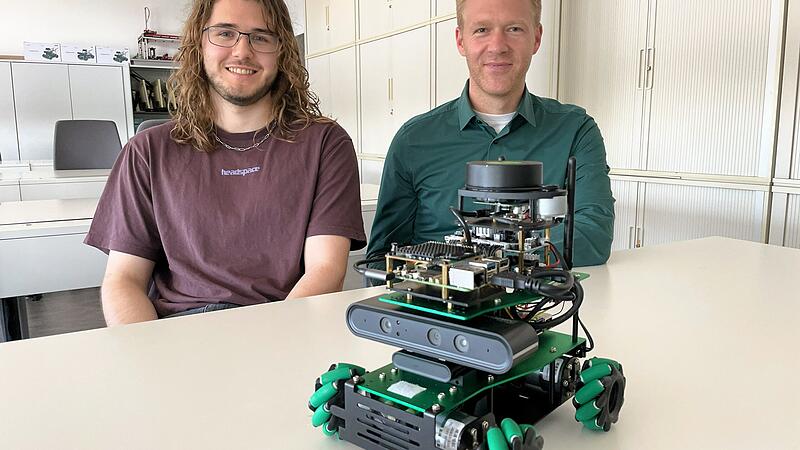 Das Unternehmen Siemens vermittelt KI-Kompetenz von Anfang an. Unter AuDas Unternehmen Siemens vermittelt KI-Kompetenz von Anfang an. Unter Aufsicht des Auszubildendenleiters Alexander Bach (r.) haben Azubis wie Micha Walter (l.) einen selbstfahrenden Roboter programmiert. Das Organisationstalent kann mittels KI einen digitalen Plan von einem Lager erstellen.fsicht des Auszubildendenleiters Alexander Bach (r.) haben Azubis wie Micha Walter (l.) einen Organisations-Roboter programmiert. Er kann mittels KI einen digitalen Plan von einem Lager erstellen.