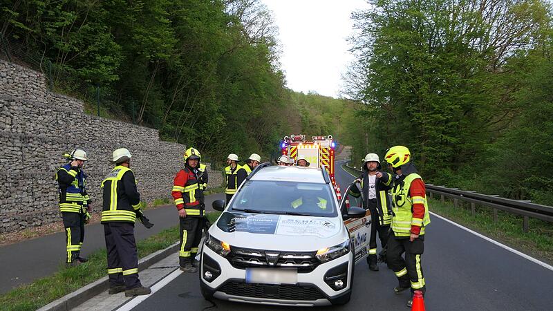 Mit Muskelkraft schoben die Einsatzkr&auml;fte das Auto &uuml;ber den Fahrradweg auf einen Gr&uuml;nstreifen