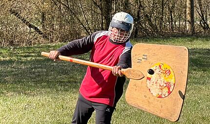 Schweizer Hornusser in geheimer Mission in Münnerstadt Gut zu erkennen: der schwarze Hornuss wird vom Spieler mit der Schindel "abgetan", bevor er auf den Boden fällt - Punkt für die Schindelmannschaft.