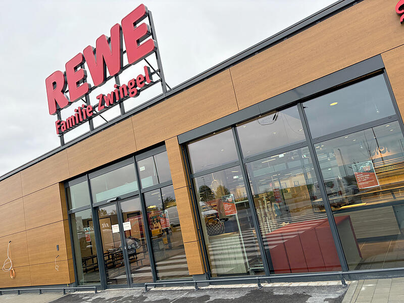 Von weitem sichtbar: Die Au&szlig;enfassade des neuen Rewe in Lonnerstadt mit ihrer roten Leuchtreklame