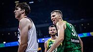 Vaidas Kariniauskas (rechts), vor einem Jahr noch Spieler von Brose Bamberg, streckt dem Amerikaner Austin Reaves nach einer erfolgreichen Aktion die Zunge heraus. Im Hintergrund beobachtet sein Mitspieler Tomas Dimsa die Aktion des Point Guards.