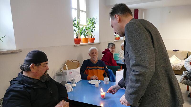 Erzbischof Herwig G&ouml;ssl hat das Friedenslicht aus Betlehem mitgebracht und verteilt es an die G&auml;ste der W&auml;rmestube.