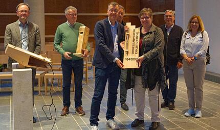 Sven Pastowski &uuml;berreicht den symbolischen Spendenscheck an Pfarrerin Elke Dollinger. Hinten (v.l.): Kantor Gerald Fink, Dieter Weidlich, Oliver Sch&uuml;rrle, Uwe Aegerter und Ute Stopfer.
