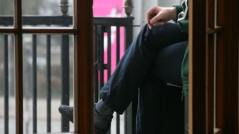 Ein Raucher auf einem Balkon