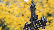 Ein eisernes Kreuz auf einem Friedhof. An Allerheiligen, dem 1. November, gedenken die Menschen der Verstorbenen und besuchen die Friedhöfe