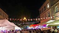 Bamberger Sandkerwa 2023 eröffnet: Massen strömen in die Altstadt - so war der erste Tag Nachtfest mit Menschenmenge bei der Bamberger Sandkerwa. Bunte Wimpelketten schmücken die Straße, beleuchtete Stände und Zelte sind zu sehen. Lebhafte Atmosphäre bei einer Feier.