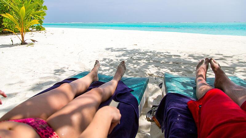 Ein paar liegt am Strand der Malediven: Manche Firmen in der Region erm&ouml;glichen ein Sabbatical, ein mehrw&ouml;chiges Ausspannen.