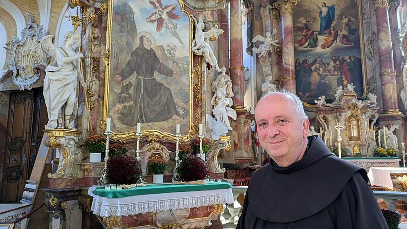Pater Maximilian Wagner in der Basilika Vierzehnheiligen vor dem Altarbild, das den Heiligen Franziskus zeigt. Seit 1839 betreuen die Franziskaner die Wallfahrtskirche.