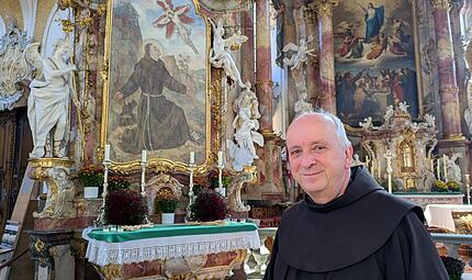 Pater Maximilian Wagner in der Basilika Vierzehnheiligen vor dem Altarbild, das den Heiligen Franziskus zeigt. Seit 1839 betreuen die Franziskaner die Wallfahrtskirche.