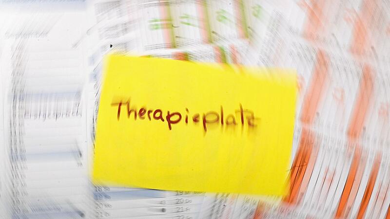 Zettel mit dem Schriftzug «Therapieplatz» liegt auf Kalendern