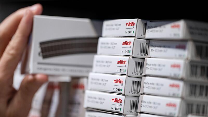 Eine Frau nimmt ein Gleis aus einem Regal