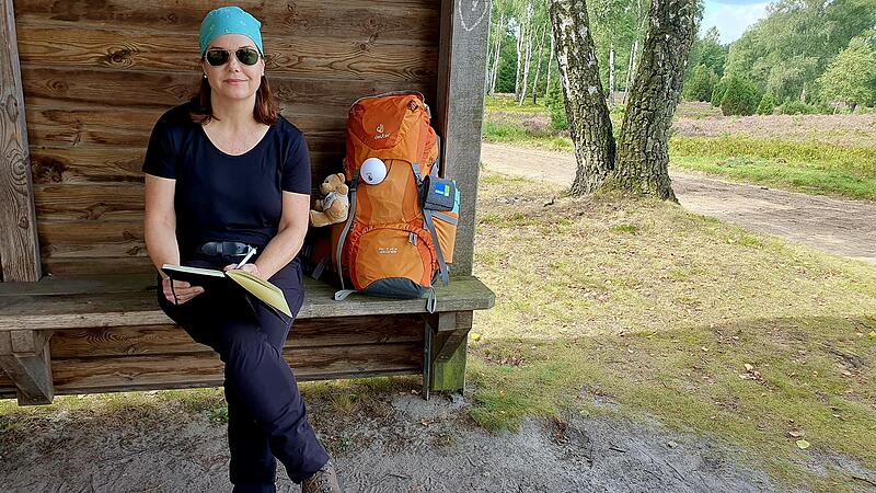 In der Oberoher Heide tr&auml;gt sich BR-Redakteurin Christine Fischer in ein  Wanderbuch ein.