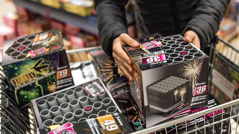 Eine Person legt Feuerwerk in einen Einkaufswagen