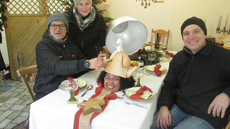 F&uuml;r einen Gag sind die Mitarbeiter der Lebenshilfe-Werkstatt immer zu haben. Unter der Warmhaltehaube der festlich geschm&uuml;ckten Tafel lugte beim Hammelburger Altstadt-Advent ein Frauenkopf unter einem Plastik- H&auml;hnchen hervor.