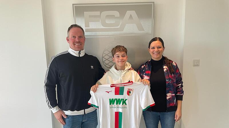 Vertrag perfekt: Leonhard Mahr pr&auml;sentiert stolz sein k&uuml;nftiges Trikot vom FC Augsburg; links Vater Steffen und rechts Mutter Madeleine.