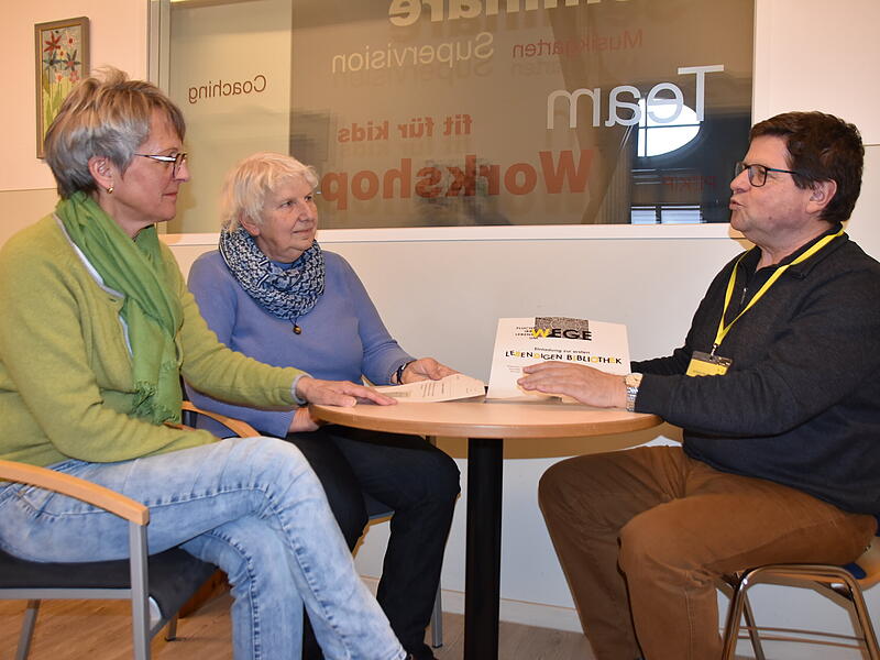 Ein lebendiges Buch erz&auml;hlt seine Geschichte und tauscht sich mit den Zuh&ouml;rern aus &ndash; hier Erich Olbrich als &bdquo;Buch&ldquo; und Elsbeth Oberhammer (links) und Barbara Biella als interessierte B&uuml;cherw&uuml;rmer.