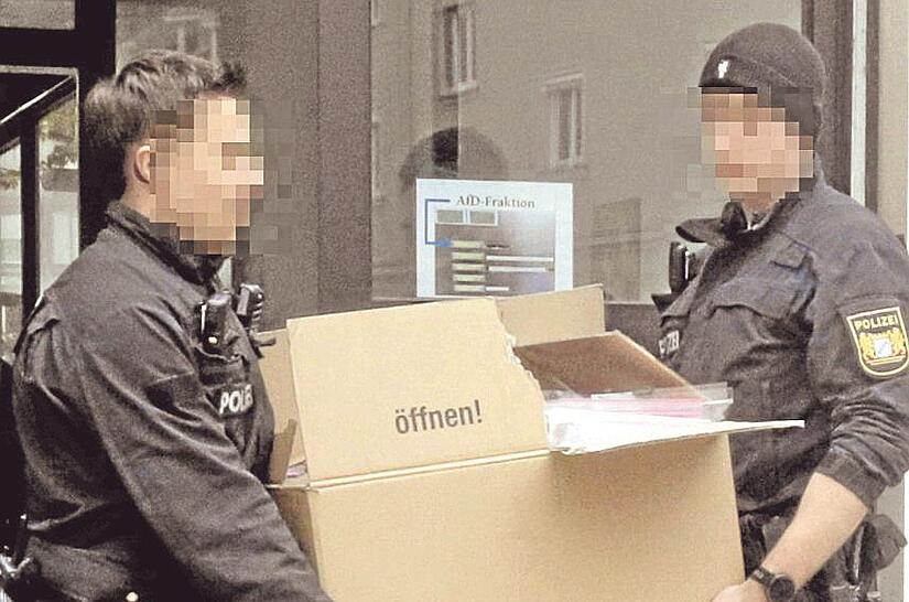 Polizeibeamte tragen beschlagnahmtes Material aus den Räumen der AfD-Stadtratsfraktion in Augsburg. Polizeibeamte tragen beschlagnahmtes Material aus den Räumen der AfD-Stadtratsfraktion in Augsburg.