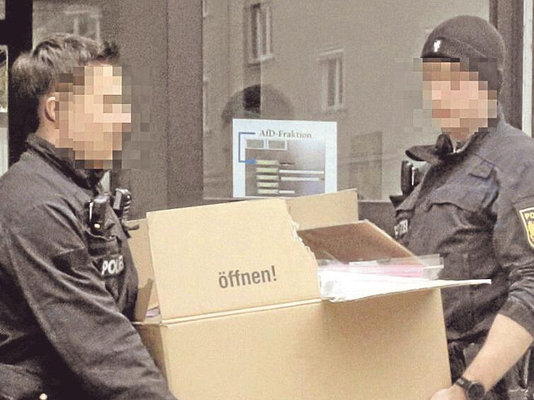 Polizeibeamte tragen beschlagnahmtes Material aus den R&auml;umen der AfD-Stadtratsfraktion in Augsburg.