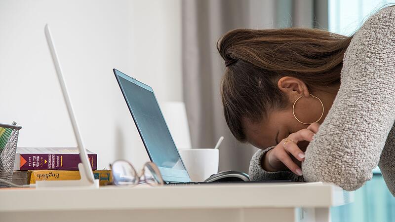 Eine junge Frau legt den Kopf auf den Tisch Eine junge Frau legt den Kopf auf den Tisch