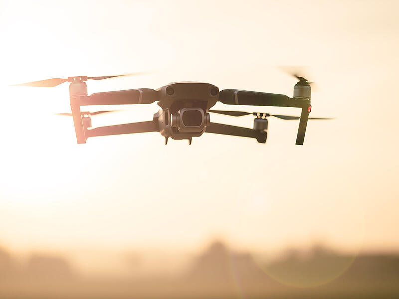 Drone like Mavic 2 Pro flying during sunset.